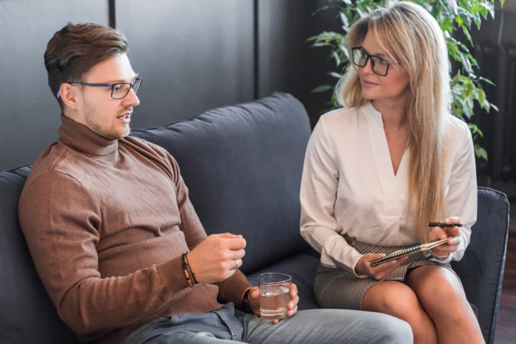 Consultation individuelle en cabinet de sophrologie : une praticienne en écoute active accompagne un homme pour une séance de gestion du stress et de développement personnel.